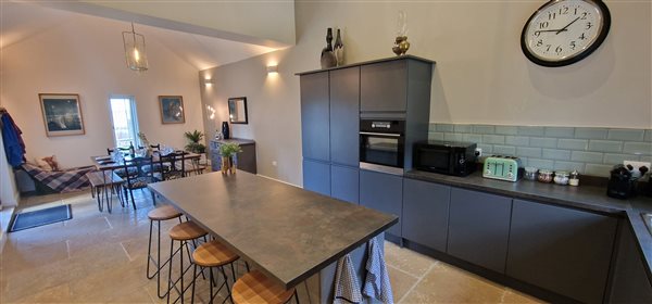 kitchen diner, large central island with 4 bar stools, vaulted ceiling above the kitchen area